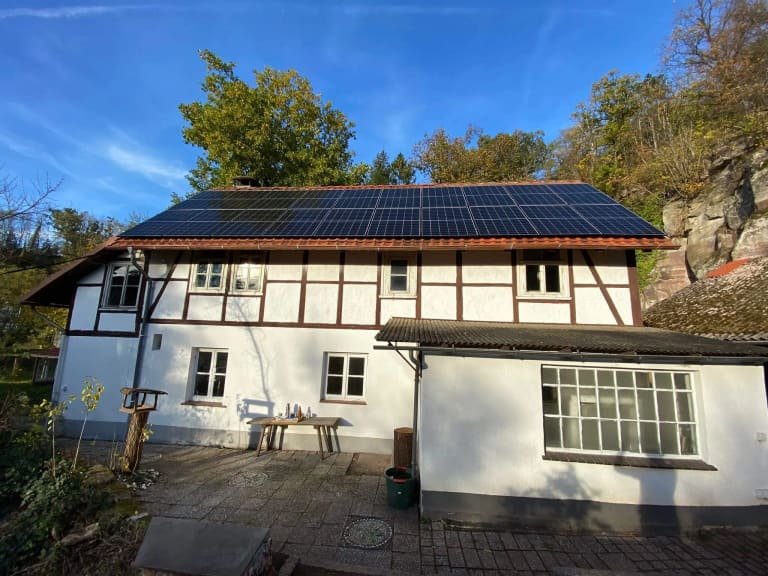 Fachwerkhaus mit Photovoltaikanlage auf dem Dach, Blick über den Hof